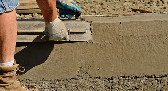 A construction worker is working on a concrete slab